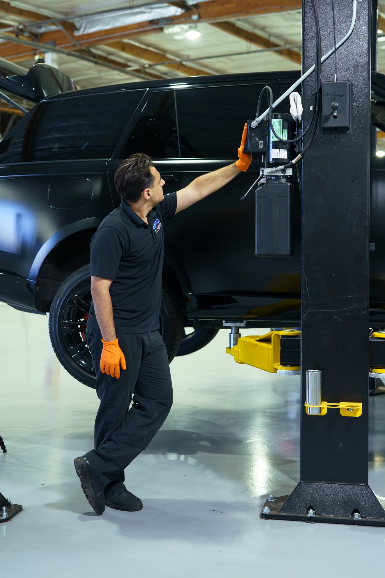 PC Automotive technician raising a vehicle on a Challenger lift