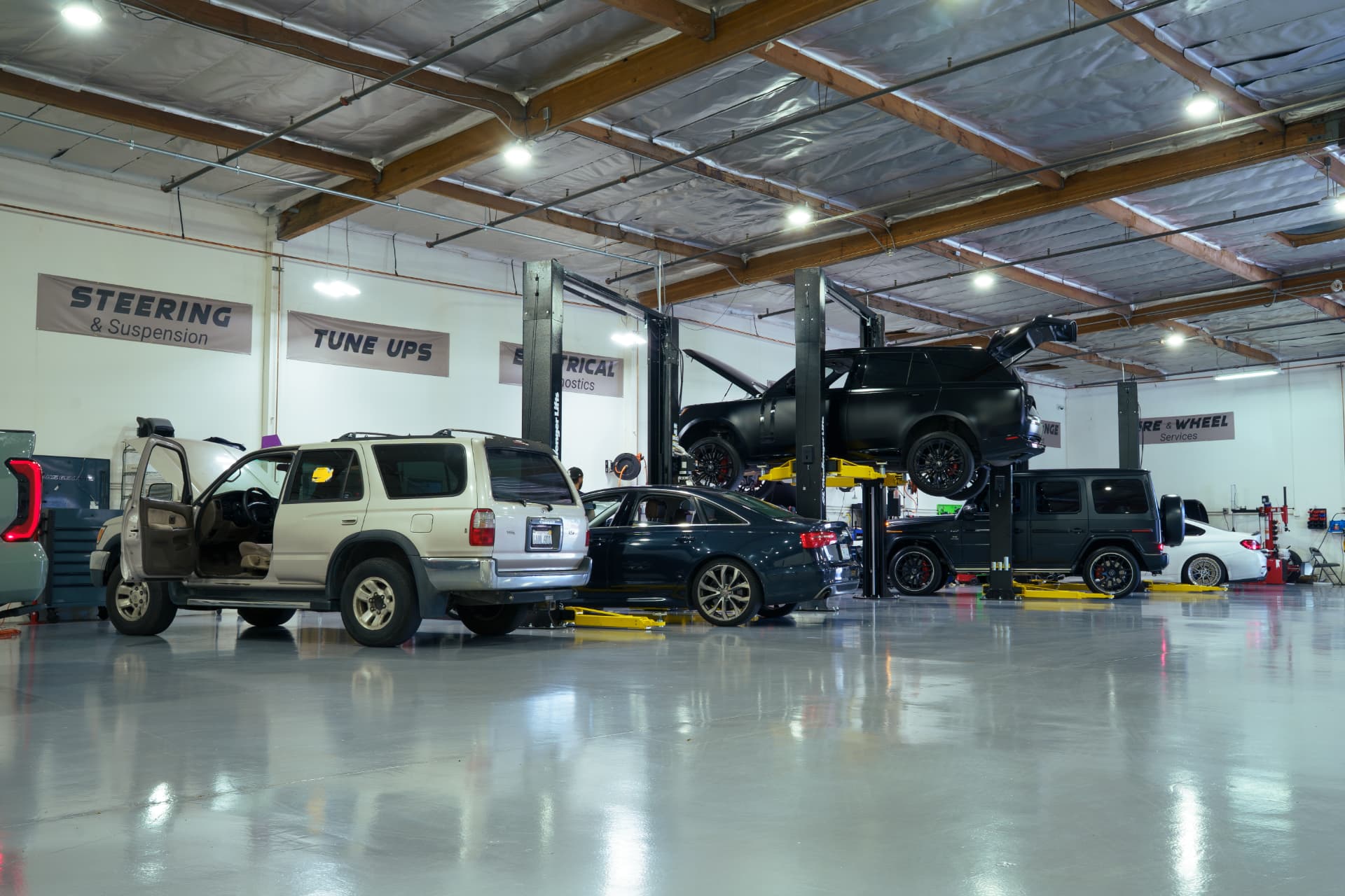 Service bays with vehicles on lifts for steering, suspension and tune-up work